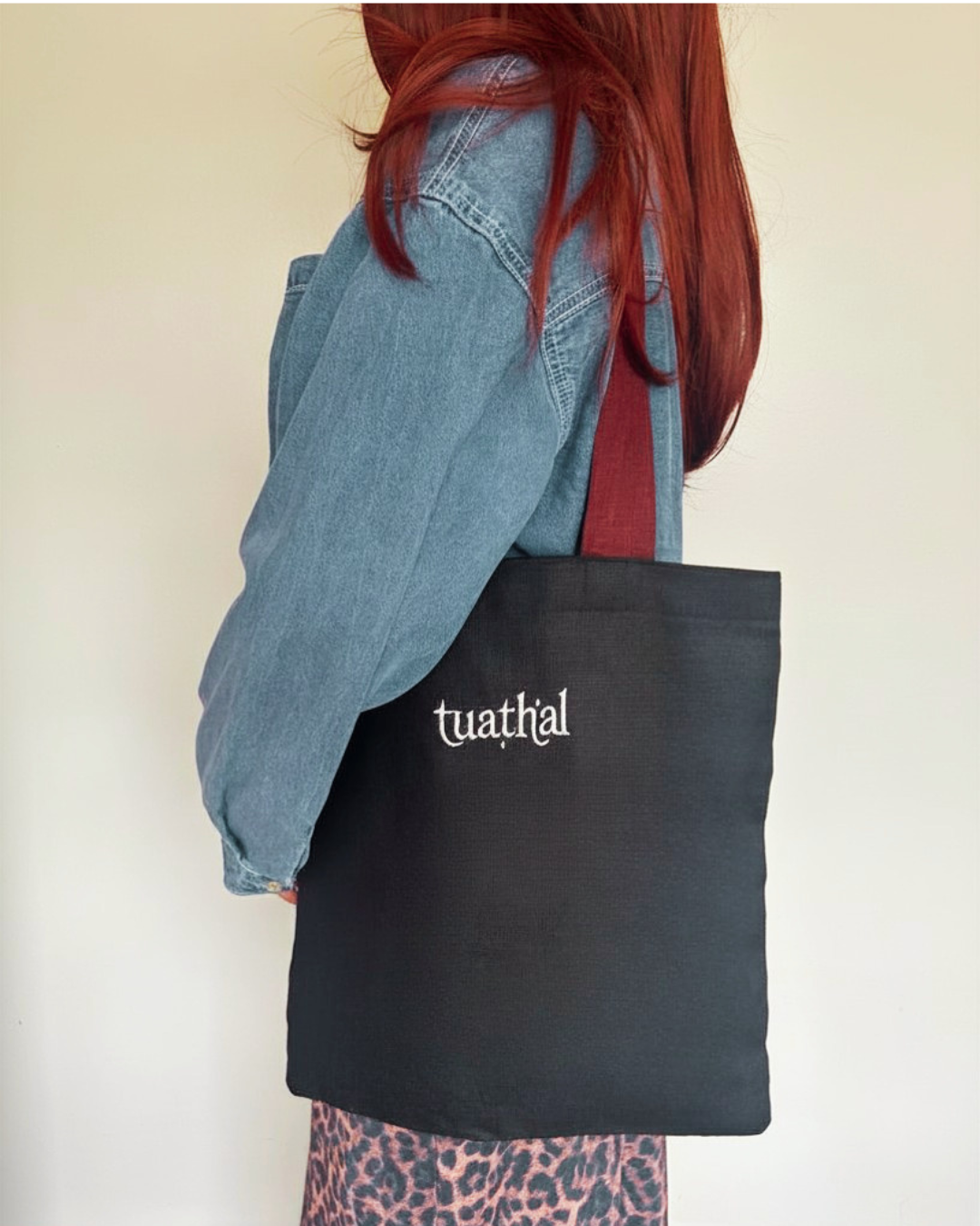 Red haired woman holding Tuathal black linen tote bag on shoulder 