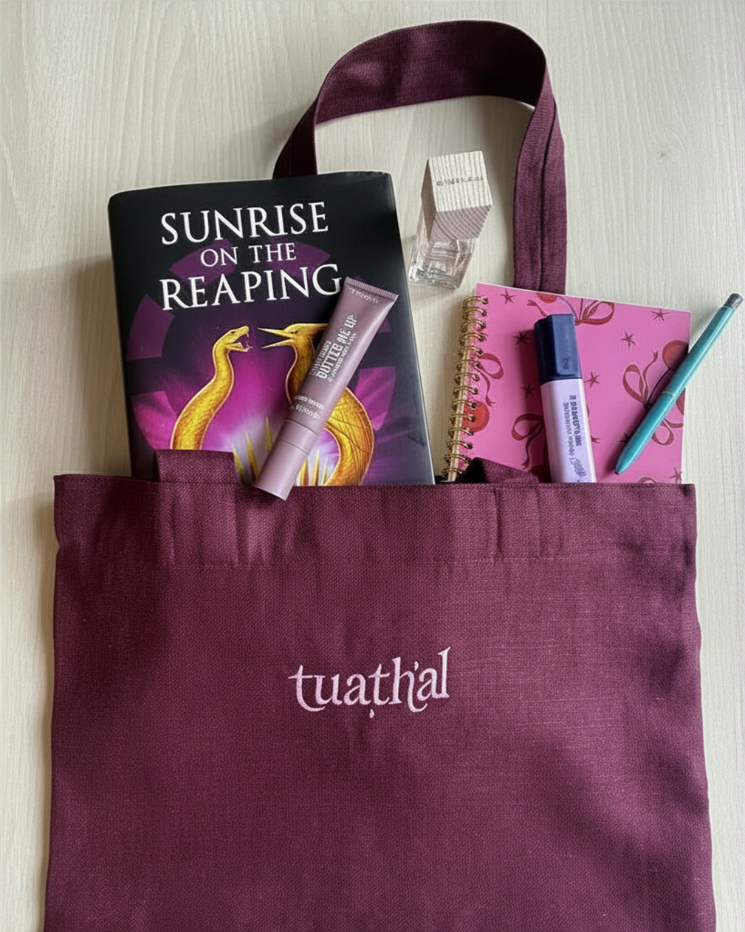 Tuathal Dark Red Linen Tote bag on desk with contents peaking out of top 