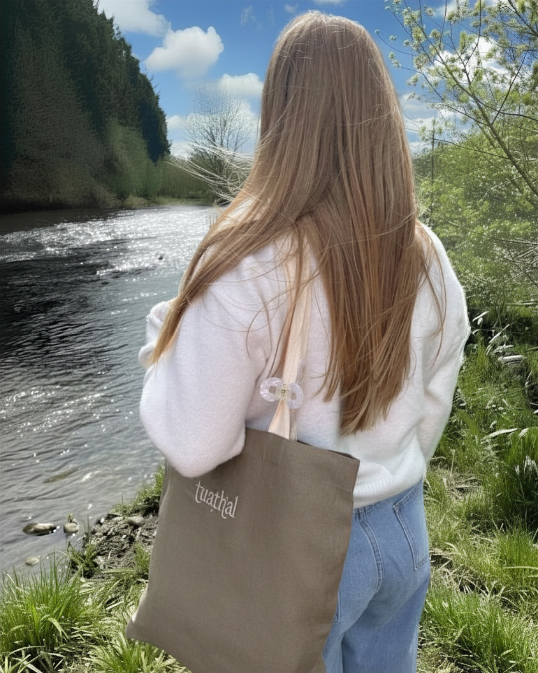 Woman looking over river holding Tuathal brown linen tote bag on shoulder 
